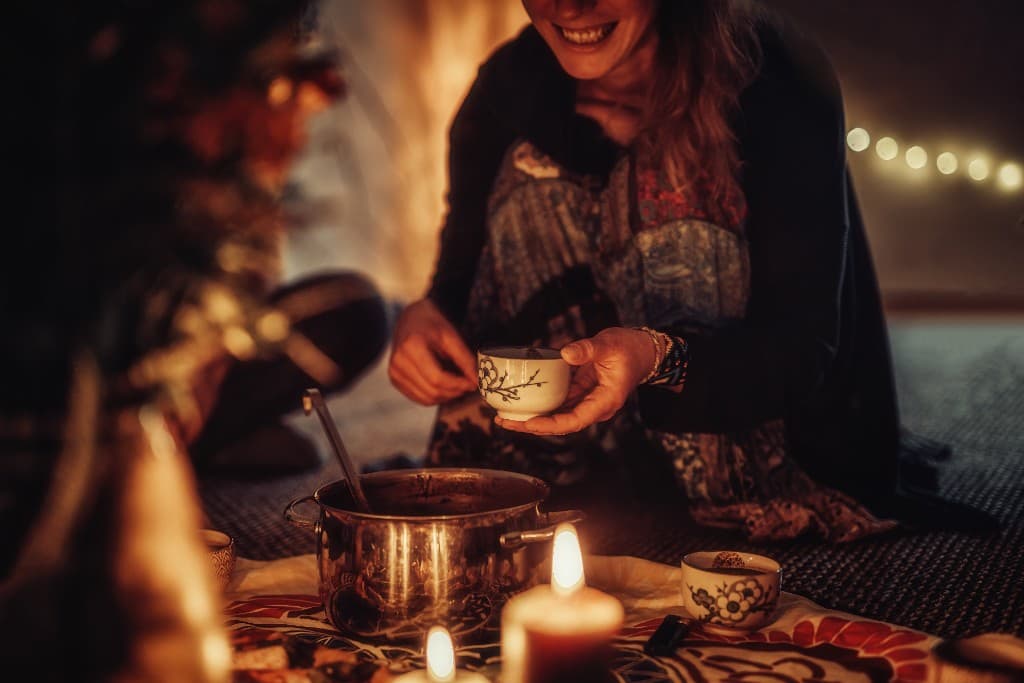 Warm candlelit tea ceremony with shared cups